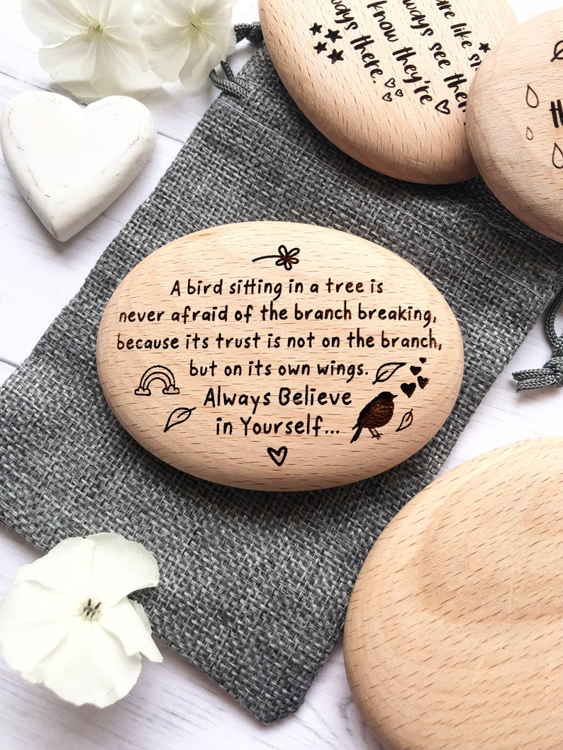 May include: Three wooden heart-shaped ornaments with inspirational quotes. The first ornament says "Always see the good in people, they're always there." The second ornament says "A bird sitting in a tree is never afraid of the branch breaking, because its trust is not on the branch, but on its own wings. Always Believe in Yourself..." The third ornament is blank.