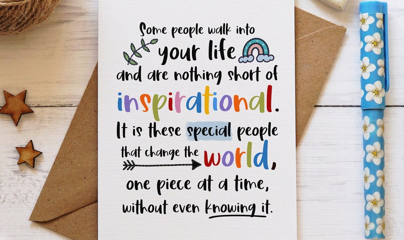 May include: A white greeting card featuring black text that reads: Some people walk into your life and are nothing short of inspirational. It is these special people that change the world, one piece at a time, without even knowing it. The card includes a small green leaf, a colorful rainbow, and a black arrow graphic.