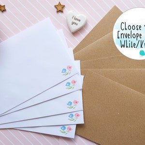 Puede incluir: Sobres de papel blanco y kraft. Los sobres blancos presentan una peque&ntilde;a ilustraci&oacute;n de dos p&aacute;jaros en una rama. El texto "Choose your Envelope Style! White/Kraft." se muestra en un gr&aacute;fico circular.