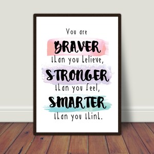 May include: A motivational quote printed on a white background with a black frame. The quote reads "You are BRAVER than you believe, STRONGER than you feel, SMARTER than you think."