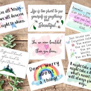 Puede incluir: Ocho tarjetas de acuarela con citas inspiradoras. Las tarjetas presentan una variedad de dise&ntilde;os, incluyendo estrellas, flores, arco&iacute;ris y una escena de monta&ntilde;a. Las citas incluyen: "Todos somos estrellas y todos merecemos el derecho a brillar.", "La vida es demasiado corta para verse como algo m&aacute;s que hermoso.", "Eres m&aacute;s hermoso de lo que crees.", "Los caminos dif&iacute;ciles a menudo conducen a hermosos destinos.", "&iexcl;No te preocupes por nada!", "Recuerda... eres m&aacute;s valiente de lo que crees, m&aacute;s fuerte de lo que sientes y m&aacute;s inteligente de lo que piensas.", "Por si acaso te has olvidado hoy... Importas. Eres amado. Eres digno. Eres m&aacute;gico.", y "Puede que lleve un a&ntilde;o, puede que lleve un d&iacute;a, pero lo que est&aacute; destinado a ser, siempre encontrar&aacute; su camino..."