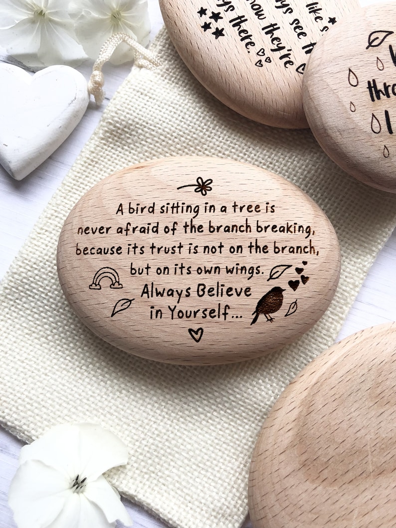 May include: Wooden engraved motivational quote on a small oval shaped piece of wood. The quote reads "A bird sitting in a tree is never afraid of the branch breaking, because its trust is not on the branch, but on its own wings. Always Believe in Yourself..."