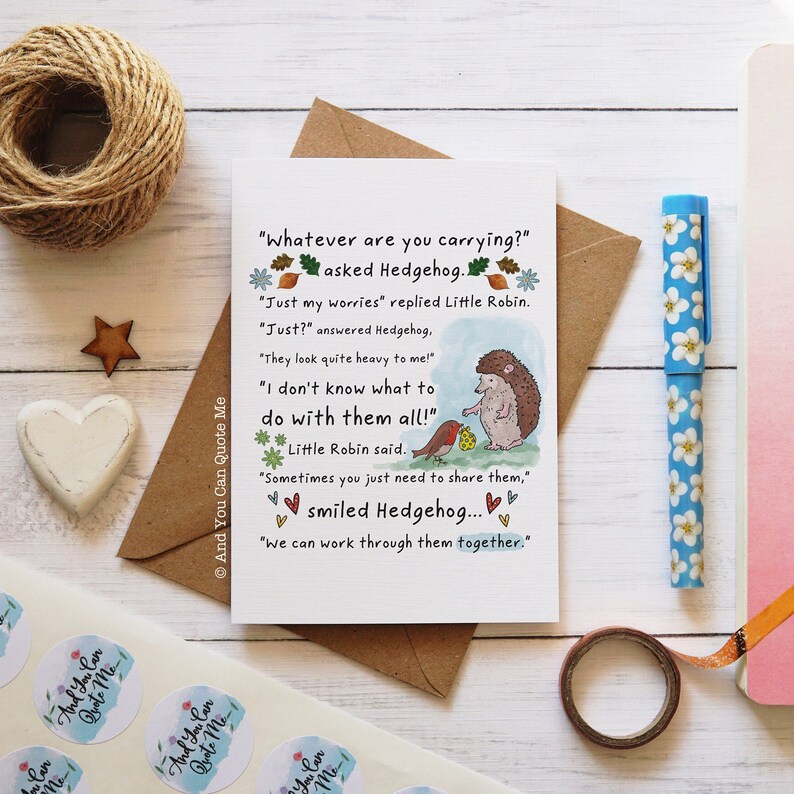 Puede incluir: Una tarjeta de felicitaci&oacute;n con una ilustraci&oacute;n de acuarela de un erizo y un petirrojo. La tarjeta presenta una cita sobre compartir las preocupaciones y trabajar juntas para superarlas. El texto dice: "&iquest;Qu&eacute; llevas?" pregunt&oacute; el erizo. "Solo mis preocupaciones" respondi&oacute; el petirrojo. "&iquest;Solo?" respondi&oacute; el erizo. "&iexcl;Se ven bastante pesadas para m&iacute;!" "&iexcl;No s&eacute; qu&eacute; hacer con todo esto!" dijo el petirrojo. "A veces solo necesitas compartirlas," sonri&oacute; el erizo... "Podemos trabajar juntas para superarlas."