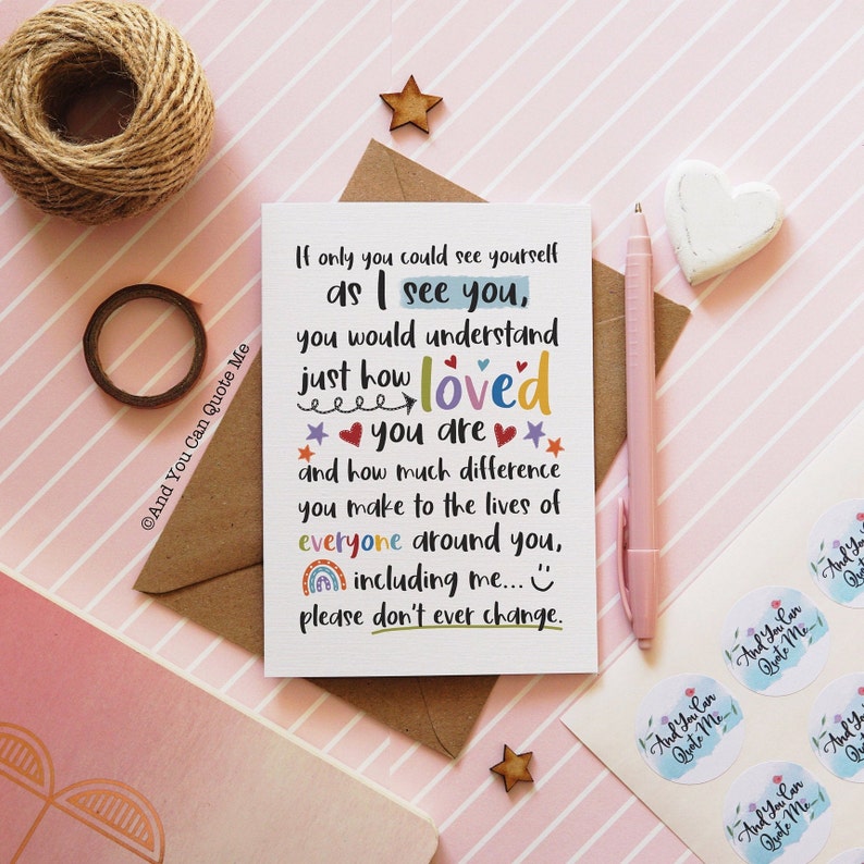 May include: A greeting card with the text "If only you could see yourself as I see you, you would understand just how loved you are..." is surrounded by stationery items, including a pen and stickers.