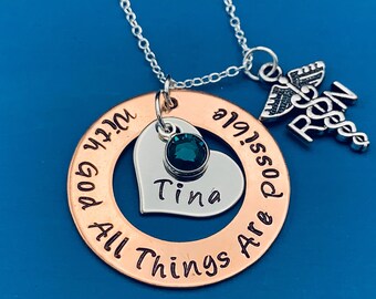 May include: A copper necklace with a heart charm, a green gemstone, and the inscription "All Things Are Possible With God" and "Tina". A silver charm with a caduceus symbol and the word "RN" is also attached to the necklace.