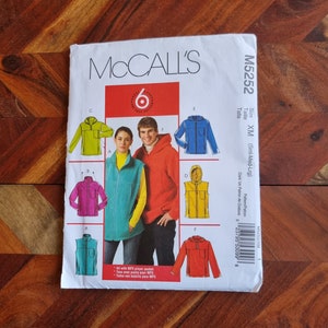 May include: McCall's sewing pattern M5252 for a hooded jacket, vest, and pullover. The pattern includes six different views, with a variety of colors and styles. The pattern is for sizes small, medium, and large.