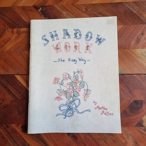 Puede incluir: Un libro vintage titulado "Shadow Work - The Easy Way" de Martha Pullen. La portada presenta un ramo de flores rosas y rojas con una cinta azul.