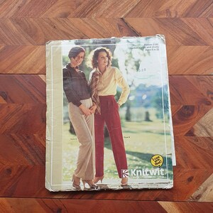 Puede incluir: Un patrón de costura vintage para pantalones y shorts de mujer, tallas 6 a 22. El patrón es de Knitwit, una marca de patrones de moda clásicos. La imagen muestra a dos mujeres modelando el patrón, una con un pantalón beige y la otra con un short rojo.