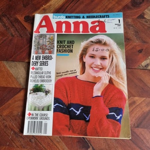 Op de afbeelding: Een tijdschriftcover voor Anna, een brei- en handwerktijdschrift. De cover toont een vrouw die een rood-blauwe gestreepte trui draagt met een witte gehaakte muts. De tekst op de cover luidt "Knit and Crochet Fashion" en "A New Embroidery Series".