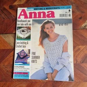Op de afbeelding: Een tijdschriftcover voor Burda Knitting & Needlecrafts Anna, met een vrouw die een wit gehaakt topje en een blauw-wit gestreepte broek draagt. De tekst op de cover luidt "Needlework you can take with you" en "Fine Summer Knits".