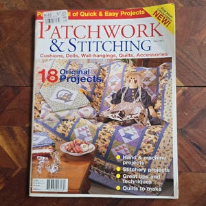 May include: The cover of "Patchwork & Stitching" magazine, featuring a doll and a quilt with a floral design. The cover text reads "18 Original Projects" and "Cushions, Dolls, Wall-hangings, Quilts, Accessories."