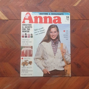 Op de afbeelding: Een vintage editie van het tijdschrift "Anna" uit oktober 1909, met brei- en naaimodellen. De omslag toont een vrouw in een crèmekleurig kabelgebreid vest. Het tijdschrift bevat patronen voor truien, jassen, poppen en kruissteken.