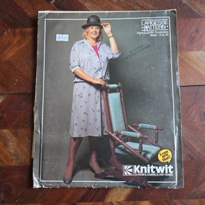 Puede incluir: Un folleto de patrones de costura vintage con una mujer que lleva un vestido estampado en gris y blanco y un sombrero marrón. El folleto se titula "Largesse Pattern" e incluye el número de patrón 2600, el texto "Ensemble" y las tallas 14 a 30. El folleto también incluye el texto "¡Puedo coser eso!" y el logotipo "Knitwit Classes, Fabrics, Patterns".