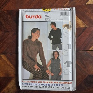 Puede incluir: Un paquete de patrones de costura de la marca Burda para una camisa y una camiseta. El paquete presenta imágenes de las prendas terminadas, incluyendo un suéter de manga larga, un top sin mangas y una camisa de manga larga. El paquete incluye el texto "CON MARGENES PARA COSTURA Y DOBLADILLOS."