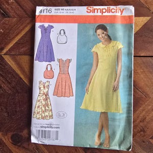 May include: Simplicity dressmaking pattern. The image shows a woman in a yellow dress and illustrations of other dress designs. These include a purple polka dot dress, a peach dress, and a floral dress. The pattern number is 4116.