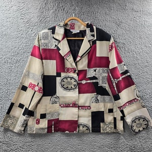May include: A patterned blazer in beige, burgundy, black, and grey with a geometric design. The blazer has a notched collar, two front pockets, and a single-button closure. The fabric features a mix of shapes and decorative elements.