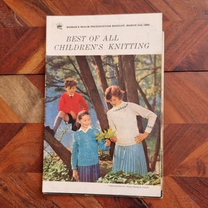 May include: A vintage booklet titled "Best of All Children's Knitting" with a cover image of three children in a forest setting. The children are wearing knitted sweaters and are holding leaves.