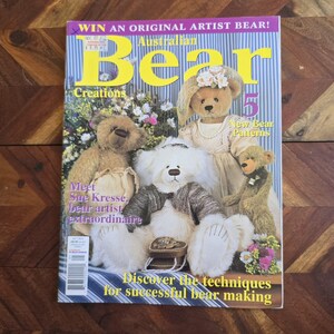 May include: The cover of "Australian Bear Creations" magazine displays multiple teddy bears. The text includes "Win an Original Artist Bear!" and "Discover the techniques for successful bear making." The magazine is on a wooden surface.
