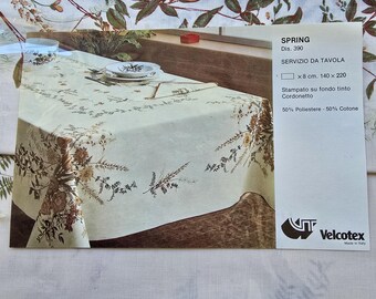 Könnte beinhalten: Eine weiße Tischdecke mit einem floralen Muster in Braun- und Grüntönen. Die Tischdecke besteht aus 50% Polyester und 50% Baumwolle. Der Text auf dem Etikett lautet "SPRING Dis. 390 SERVIZIO DA TAVOLA x 8 cm. 140 x 220 Stampato su fondo tinto Cordonetto 50% Poliestere - 50% Cotone Velcotex Made in Italy"
