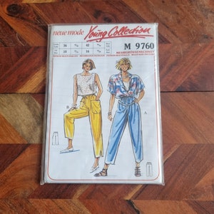 May include: A sewing pattern for a pair of trousers. The pattern includes two different styles of trousers, one in yellow and one in blue. The pattern is for sizes 36, 42, and 10. The pattern is called "Young Collection" and the pattern number is "M 9760".