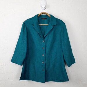 May include: Teal button-up shirt with a collared neckline and long sleeves. The shirt is made of a textured fabric and has a relaxed fit.