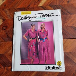 Puede incluir: Un patrón de costura vintage titulado "Designer Pattern" con un vestido rosa con un diseño floral. La portada del patrón incluye el texto "Today's Fashion Ready to Cut Out and Sew" y "The Classic Dress - Pattern 800. Tallas 6 a 22."