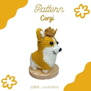 Może przedstawiać: Szydełkowa figurka psa corgi w kolorze żółtym i białym, w złotej koronie. Pies stoi na drewnianej podstawie, nad nim napis "Pattern Corgi" złotym pismem. U dołu znajduje się nazwa konta na Instagramie "@little_crochetbox".