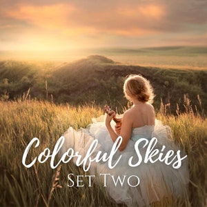 May include: A woman in a white dress plays a ukulele while sitting on a grassy hilltop. The sky behind her is a vibrant orange and pink, creating a colorful and dreamy scene. The text "Colorful Skies SET TWO" is superimposed on the image.