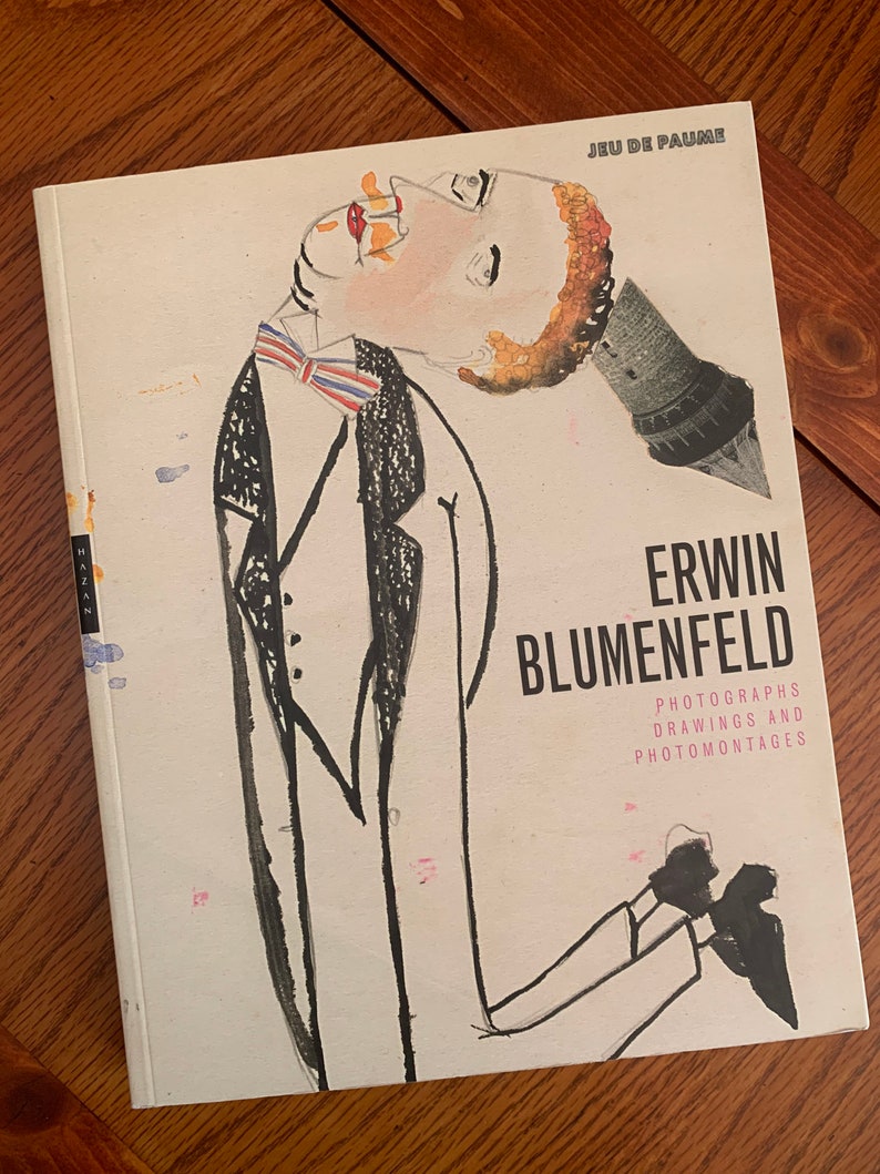 May include: A book cover with a black and white illustration of a person wearing a suit and bow tie. The title of the book is "Erwin Blumenfeld: Photographs, Drawings and Photomontages".