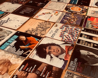 Può includere: Una collezione di dischi in vinile vintage con diverse copertine di album che presentano diversi artisti e generi. Le copertine sono colorate e presentano una varietà di design, tra cui testo, immagini e illustrazioni. Alcuni degli album includono "Wayne Newton", "Musical England", "Music of the 1920's & 1930's", "Golden Waltzes", "Andy Williams" e "Lady in the Dark".