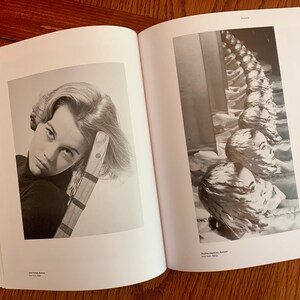 May include: A black and white photograph of a woman with her head resting on a wooden chair. The woman is looking directly at the camera with a serious expression. The photograph is from the book "Faces" by John French, New York 1969.