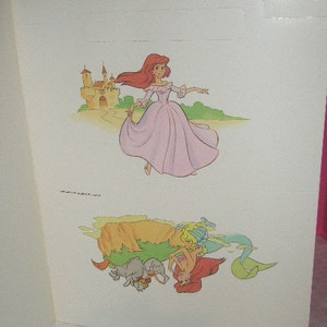 May include: A double-page spread featuring illustrations from a children's story. The top illustration depicts a princess in a pink gown near a castle. The bottom illustration shows mermaids and sea creatures.