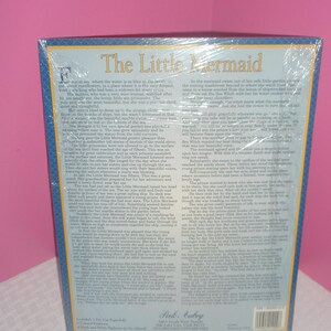 Op de afbeelding: Een puzzel in doos met de titel "The Little Mermaid" in grote, sierlijke letters. De doos heeft een blauwe rand en bevat tekst uit het verhaal. De puzzel is in plastic verzegeld.