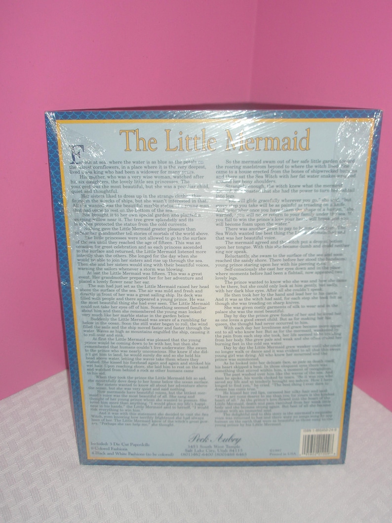 Op de afbeelding: Een puzzel in doos met de titel "The Little Mermaid" in grote, sierlijke letters. De doos heeft een blauwe rand en bevat tekst uit het verhaal. De puzzel is in plastic verzegeld.