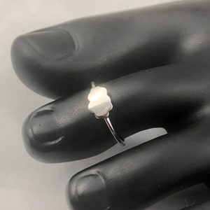 May include: A silver toe ring with a cloud-shaped design.