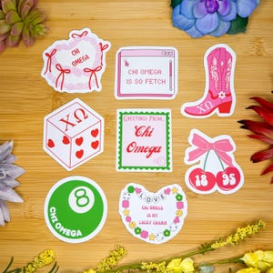 May include: A set of nine stickers featuring various designs related to the sorority Chi Omega. The stickers include a heart wreath, a computer screen with the text "Chi Omega is so fetch", a pair of cherries, a dice with the letters "XO", a cowboy boot, a green 8-ball, a heart with the text "Chi Omega is my lucky charm", and a card with the text "Greetings from Chi Omega".