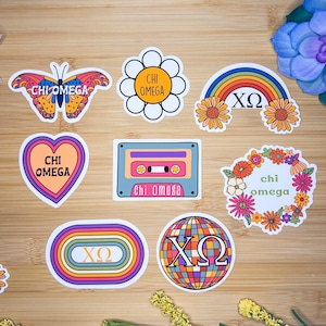 May include: Nine colorful stickers featuring different designs and the Greek letters "XO" and "Chi Omega". The stickers include a butterfly, a flower, a rainbow, a cassette tape, a heart, a wreath, a circle with concentric rings, and a disco ball.