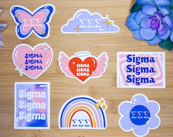 May include: Nine colourful stickers featuring the Greek letters Sigma Sigma Sigma (ΣΣΣ) in various designs. The stickers include a butterfly, a cloud, a heart with wings, a rainbow, a flower, and a text-based design.