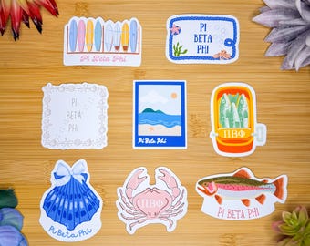 May include: A set of nine stickers featuring various beach-themed designs. The stickers feature a seashell, a crab, a fish, a beach scene, a surfboard, a fish market, and a frame with seashells. The stickers all have the text "Pi Beta Phi" on them.