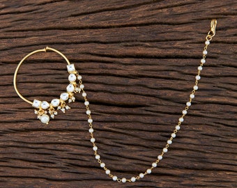 May include: A gold nose ring with a pearl and clear stone dangle and a pearl chain.
