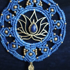 May include: A blue and silver macrame necklace with a lotus flower design and a blue gemstone pendant.