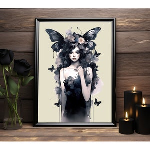 May include: A framed watercolor painting of a woman with long black hair wearing a black dress and a crown of flowers. She has butterfly wings and is surrounded by butterflies. The background is a light beige color.