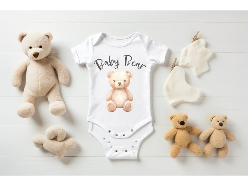 May include: White baby onesie with a brown teddy bear illustration and the text "Baby Bear".