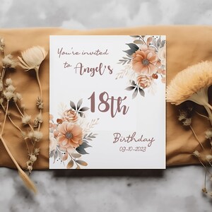 May include: A white invitation card with a floral design in shades of brown and beige. The text reads "You're invited to Angel's 18th Birthday 09-10-2023".