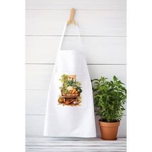 May include: White kitchen apron with a pocket featuring a colorful illustration of a basket overflowing with fresh vegetables and herbs.