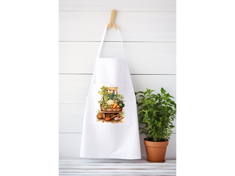 May include: White kitchen apron with a pocket featuring a colorful illustration of a basket overflowing with fresh vegetables and herbs.