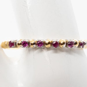 Peut inclure: Une bague en or et argent avec une rangée de petites pierres précieuses roses.