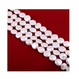 以下が含まれることがあります： 白い丸い平らな真珠のビーズのストランド。真珠は列に並べられており、すべて同じサイズです。