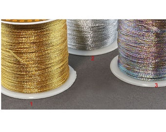 May include: Three spools of metallic thread. The first spool is gold, the second is silver, and the third is iridescent.