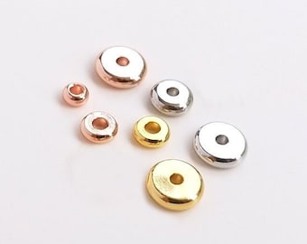 Può includere: Assortimento di perline rotonde in metallo dorate, argentate e oro rosa. Le perline sono di diverse dimensioni e hanno un foro al centro.
